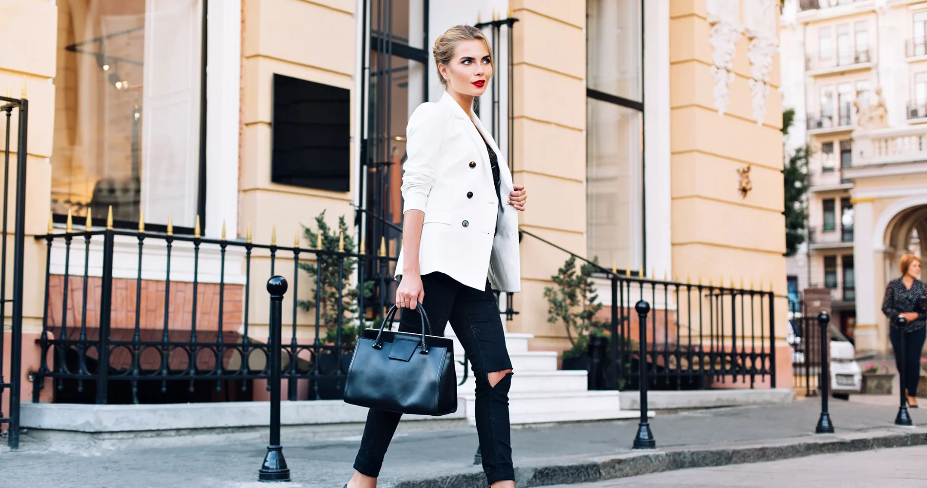 moda-donna-bionda-sui-tacchi-in-giacca-bianca-sta-camminando-sulla-strada-sta-sorridendo-a-lato copia